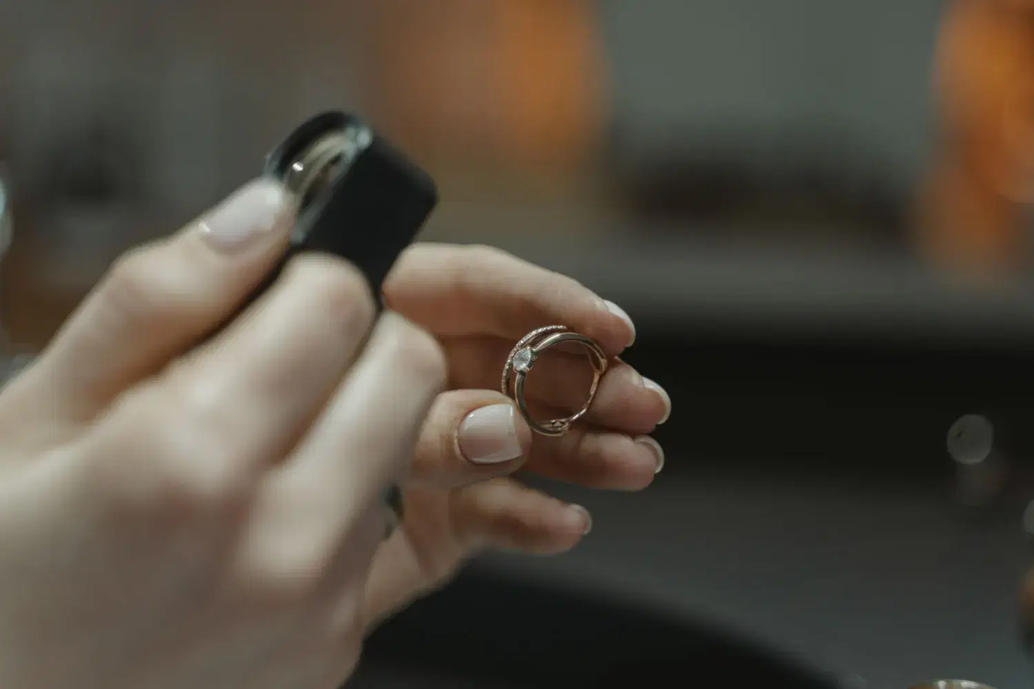 A diamond ring held up to a loupe for inspection.